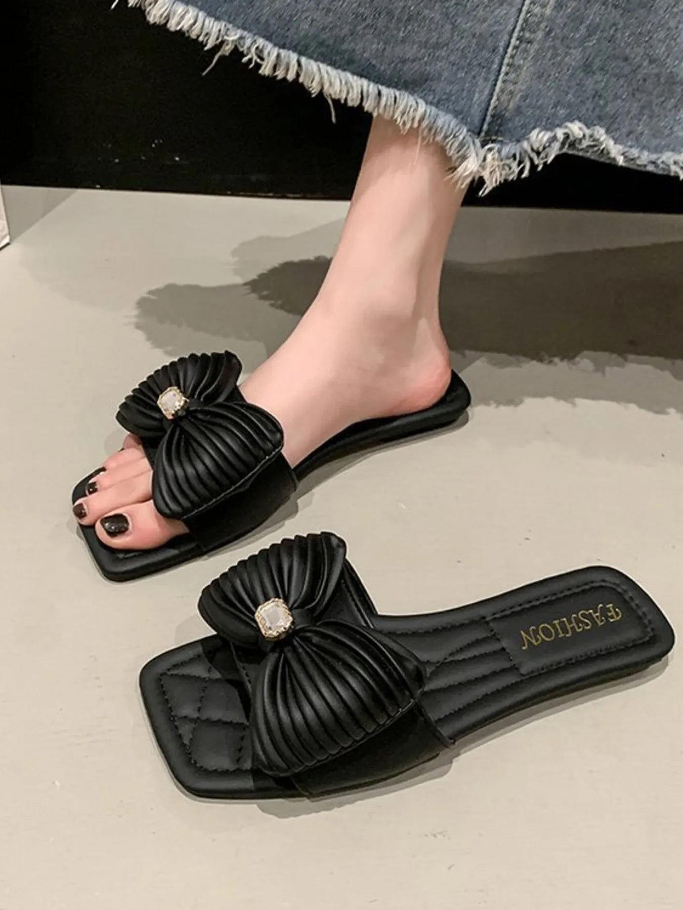 Women's beige faux leather flat sandals with a decorative bow-knot detail, stylish and comfortable for casual wear.