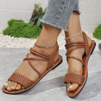 Brown braided ankle strap flat sandals made of comfortable PU leather, perfect for casual summer wear.