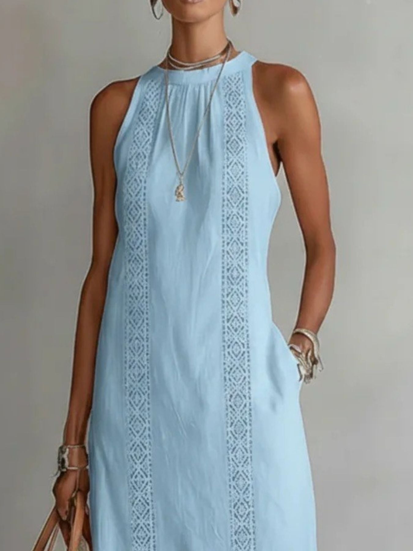 Sleeveless hollow-out midi dress by Trendsi featuring side slit and pockets, shown on a model in a stylish outdoor setting.
