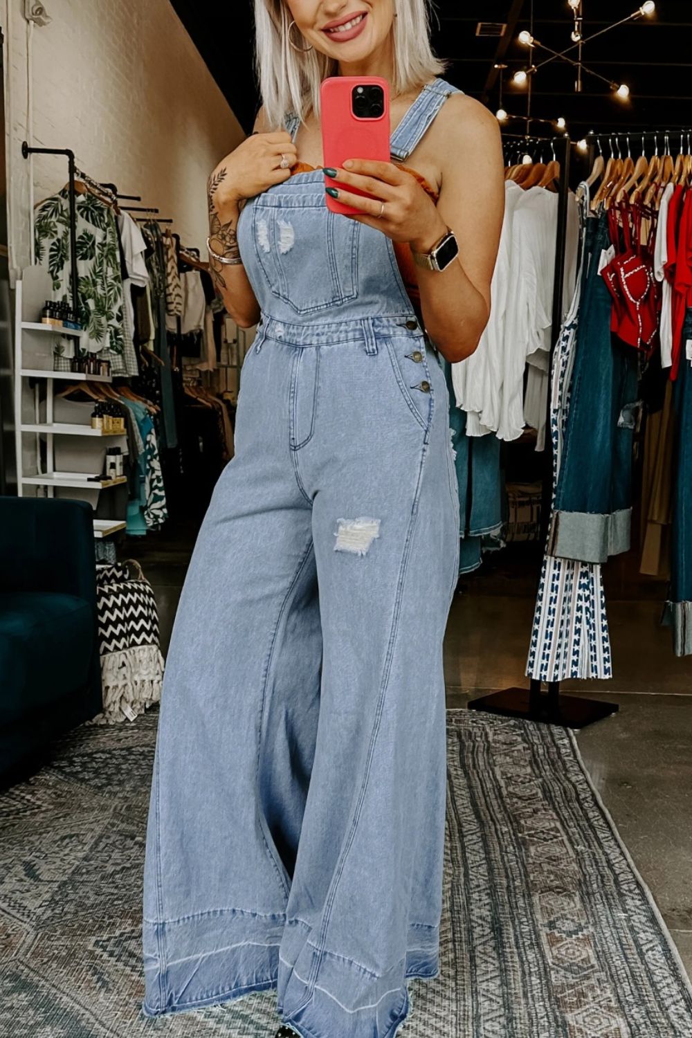 Women's distressed wide leg denim overalls with casual relaxed fit, featuring distressed details and adjustable straps.