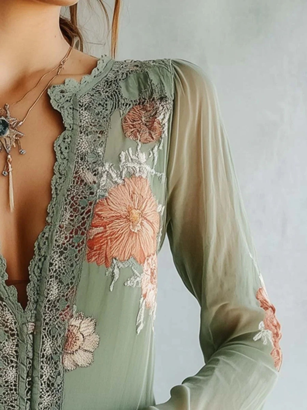 Elegant floral lace blouse by Trendsi featuring long sleeves and sophisticated feminine design, shown in a detailed close-up.
