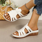 Women's chic cutout faux leather open-toe wedge sandals with ankle straps and stylish design.