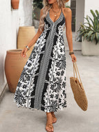 Women's printed halter neck maxi dress with tie-back detail by Trendsi, featuring vibrant pattern and flowing fabric.