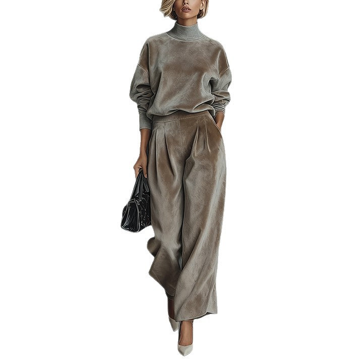 A woman wears a taupe velour high-neck long-sleeve top and matching wide-leg pleated trousers with a black handbag.