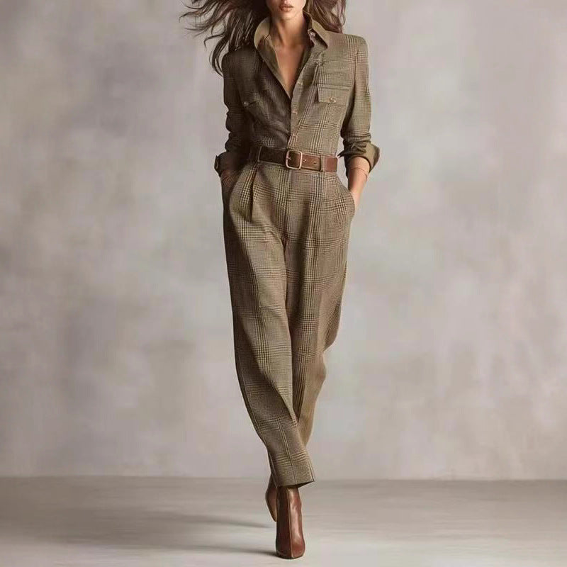 A woman models a brown plaid-print long-sleeve jumpsuit with a button-up top, chest pockets, and a brown leather belt.