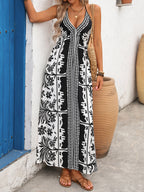Women's printed halter neck maxi dress with tie-back detail, featuring a flowy silhouette and vibrant floral pattern.