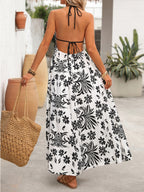 Women's printed halter neck maxi dress with tie-back detail, featuring vibrant patterns and flowing fabric by Trendsi.