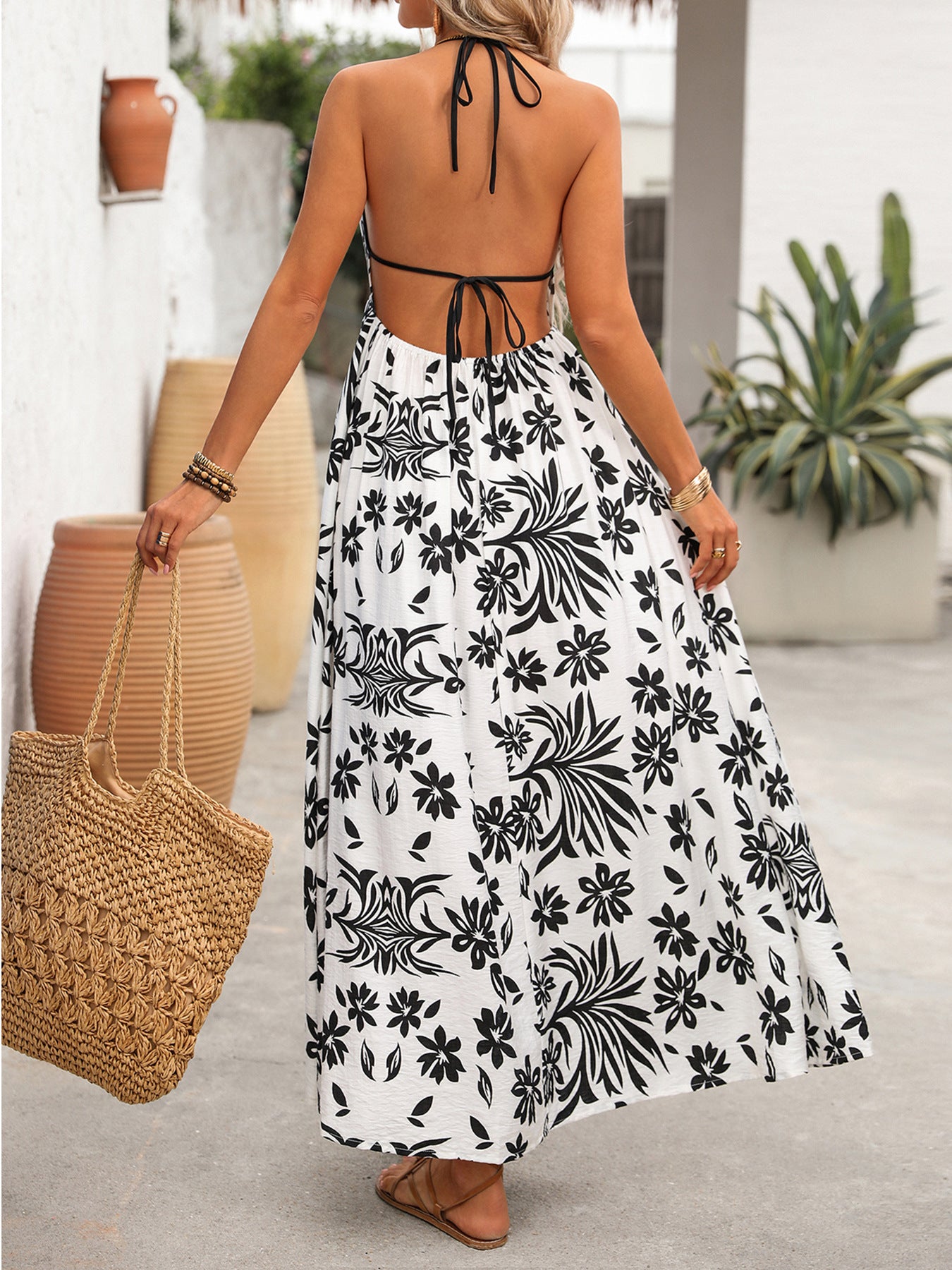 Women's printed halter neck maxi dress with tie-back detail, featuring vibrant patterns and flowing fabric by Trendsi.