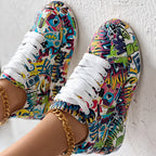 Low-top sneakers with vibrant, multi-colored graffiti and pop art prints, featuring white laces and gold anklets.
