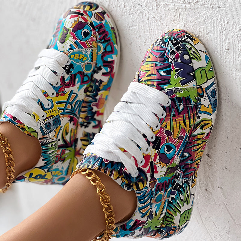 Low-top sneakers with vibrant, multi-colored graffiti and pop art prints, featuring white laces and gold anklets.