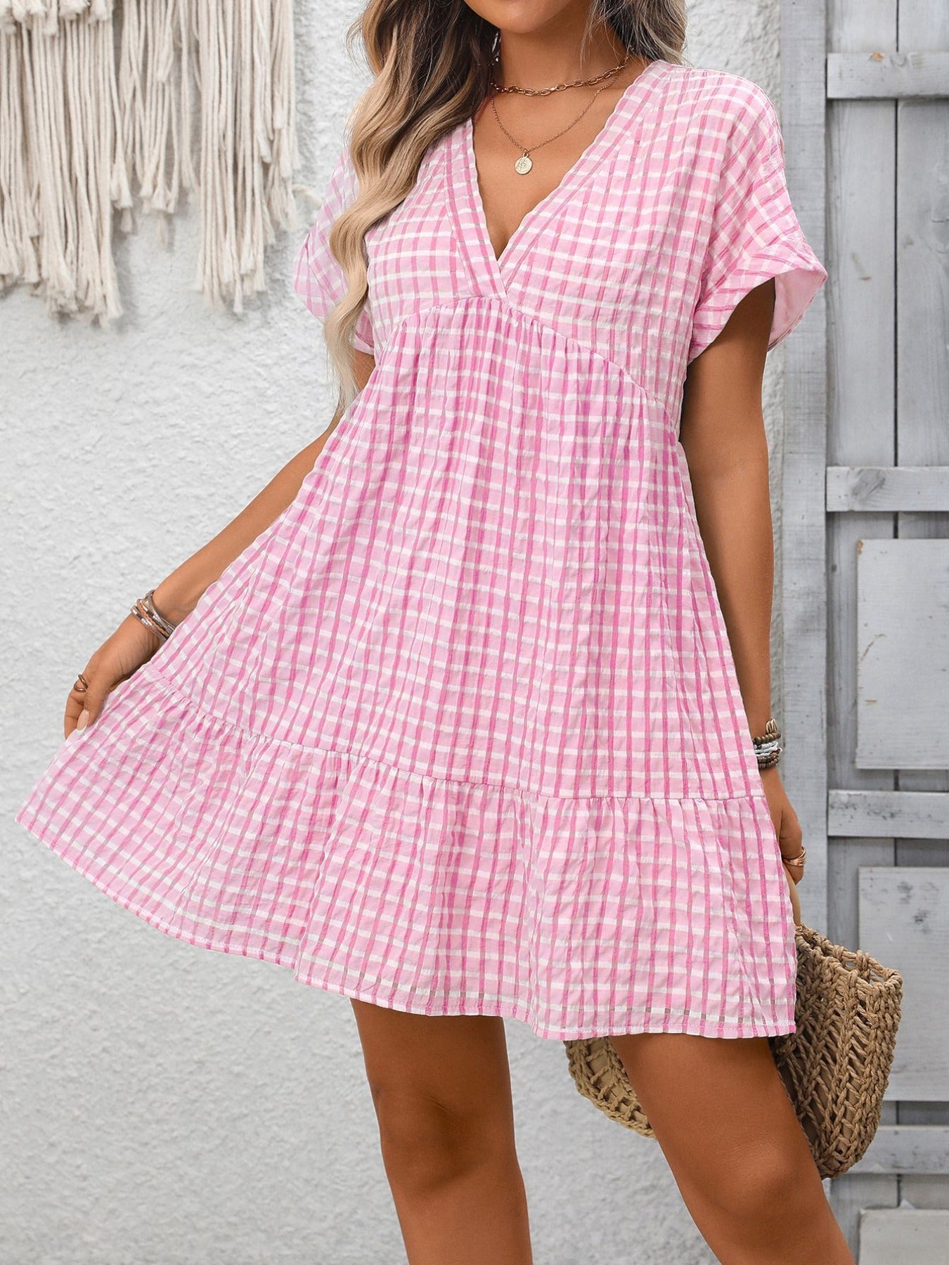 Lightweight plaid V-neck mini dress with ruffle hem from Trendsi, featuring a stylish seasonal design and feminine silhouette.