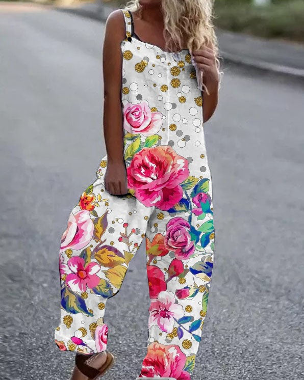 Woman wearing a white, sleeveless, wide-leg jumpsuit with colorful rose patterns and gold polka-dot accents.