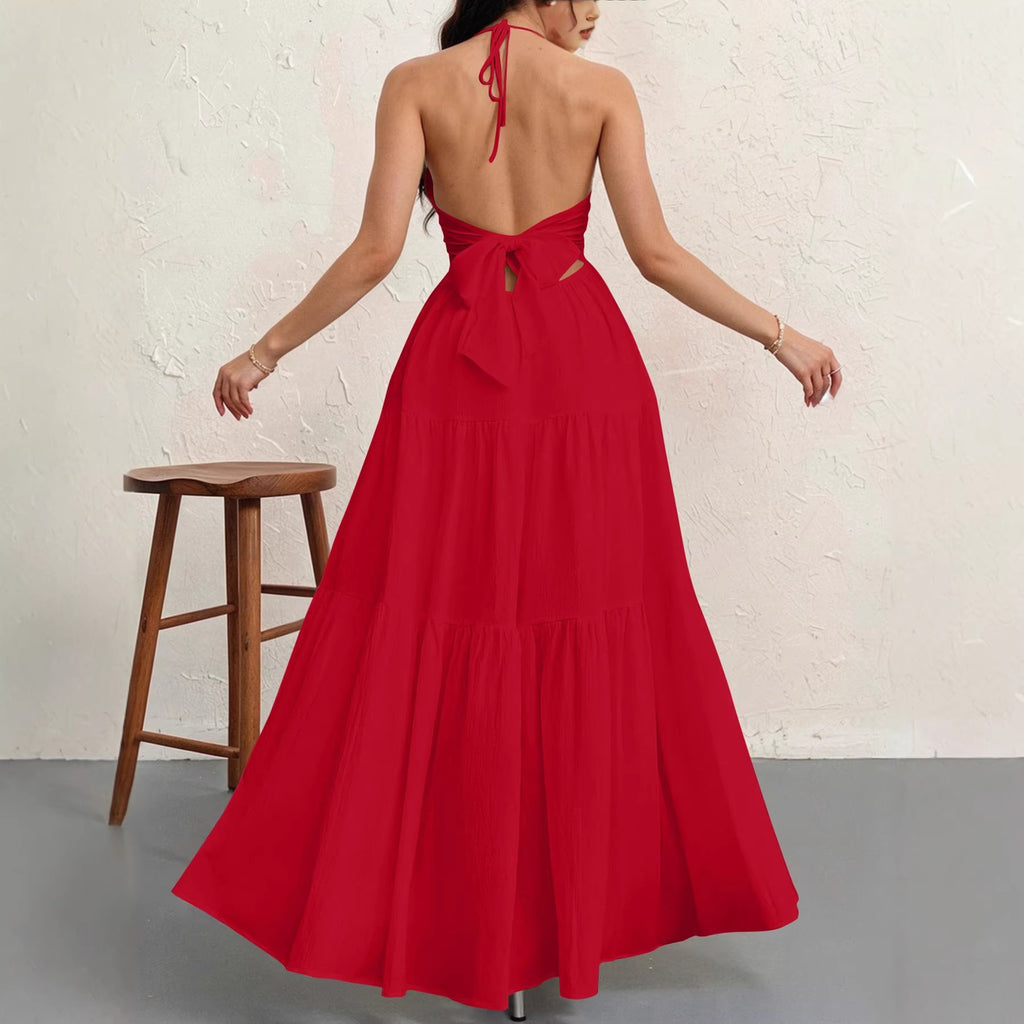 Back view of a red, tiered maxi dress with an open-back, halter neck, and large tie-waist detail.