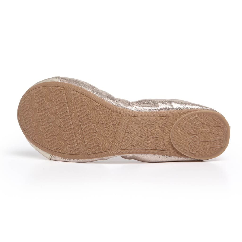 Bottom view of a shimmering champagne-colored foldable flat shoe with a tan patterned rubber sole.