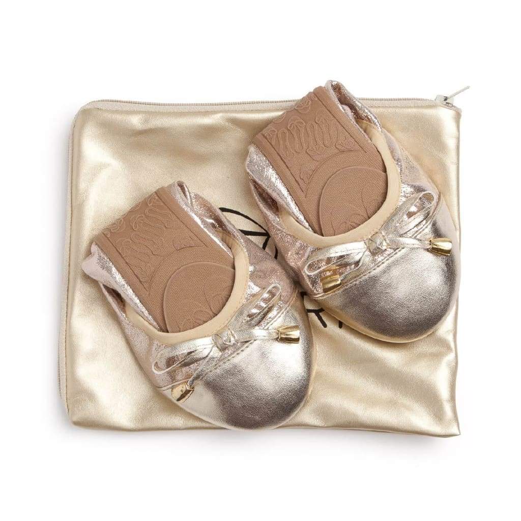 Champagne-colored metallic ballet flats with bow detail and matching travel pouch.
