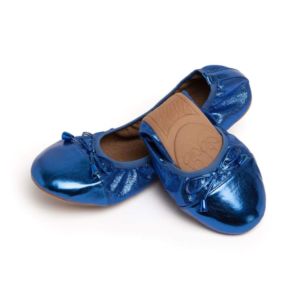 Shiny cobalt blue ballet flats with a rounded toe, bow detail, and flexible tan cushioned soles.