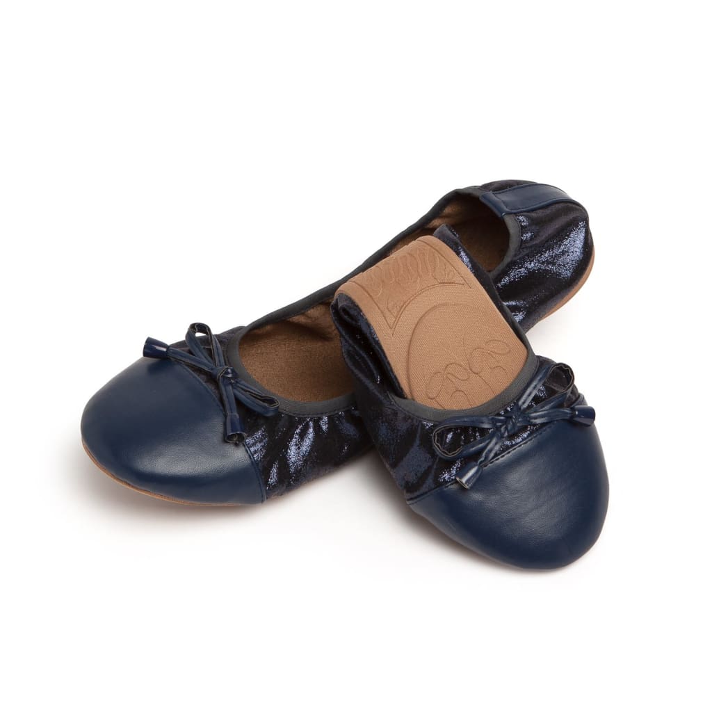 Navy blue ballet flats with a shiny, textured finish, a rounded toe, and a decorative front bow.