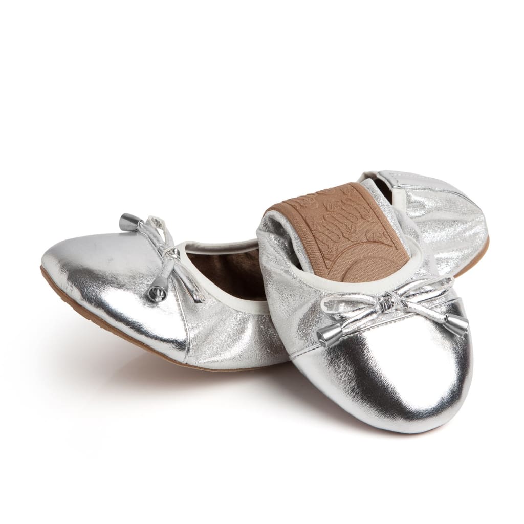 Pair of metallic silver ballet flats featuring a rounded toe and decorative bows with silver aglets.
