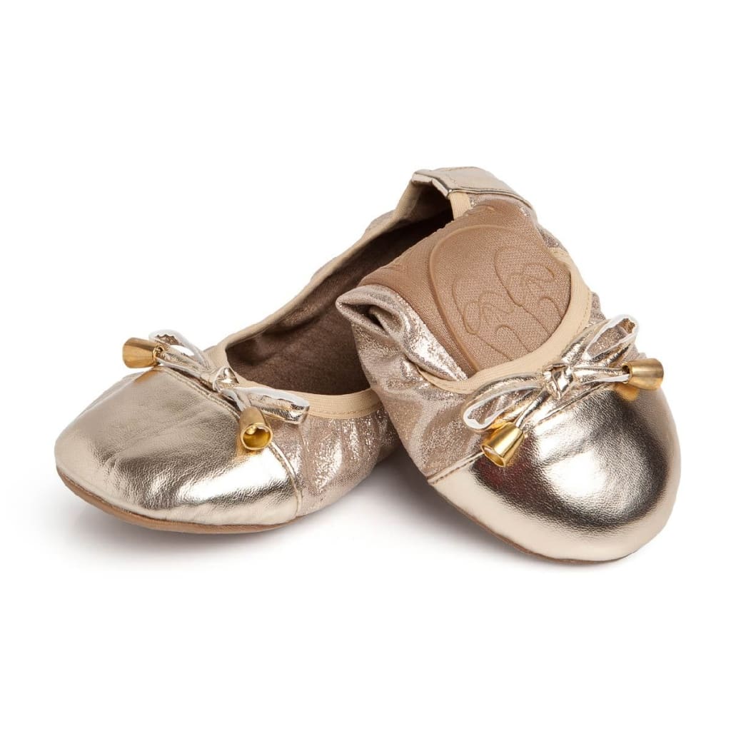 Metallic gold Talaria Littles ballet flats with a soft, gathered design, bow detail, and gold-tone aglets.
