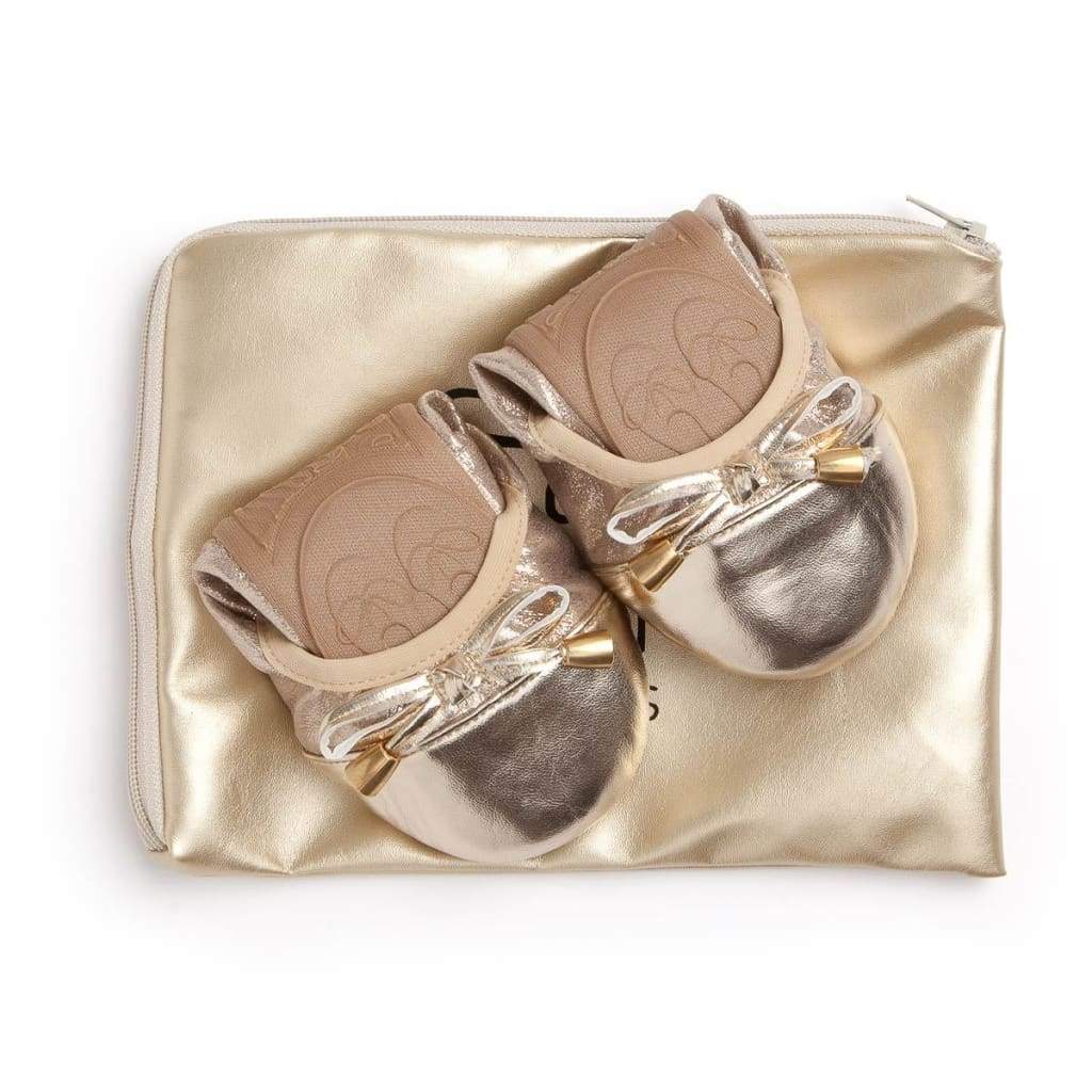 Metallic gold foldable ballet flats with decorative bows on a matching gold zipper pouch.