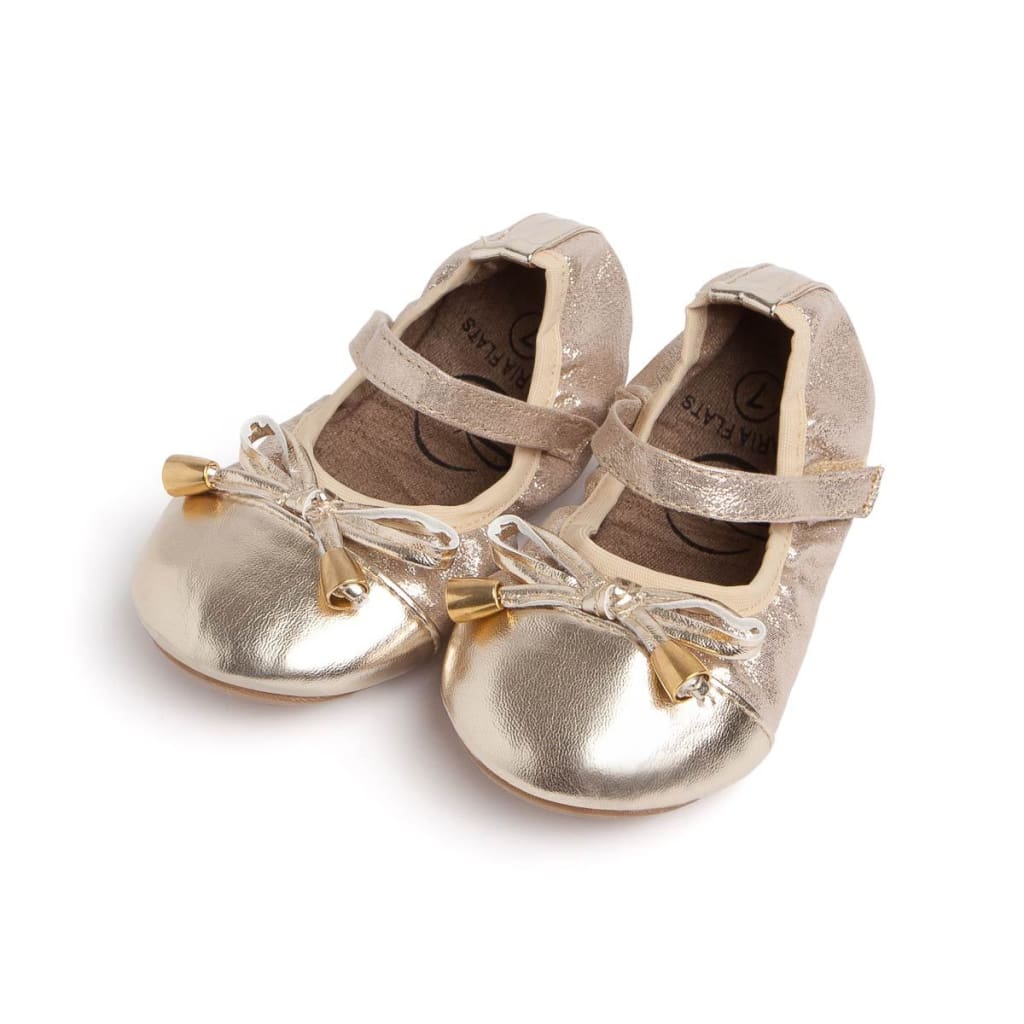 Metallic gold Talaria Littles toddler flats with a Mary Jane strap and a decorative bow with gold aglets.