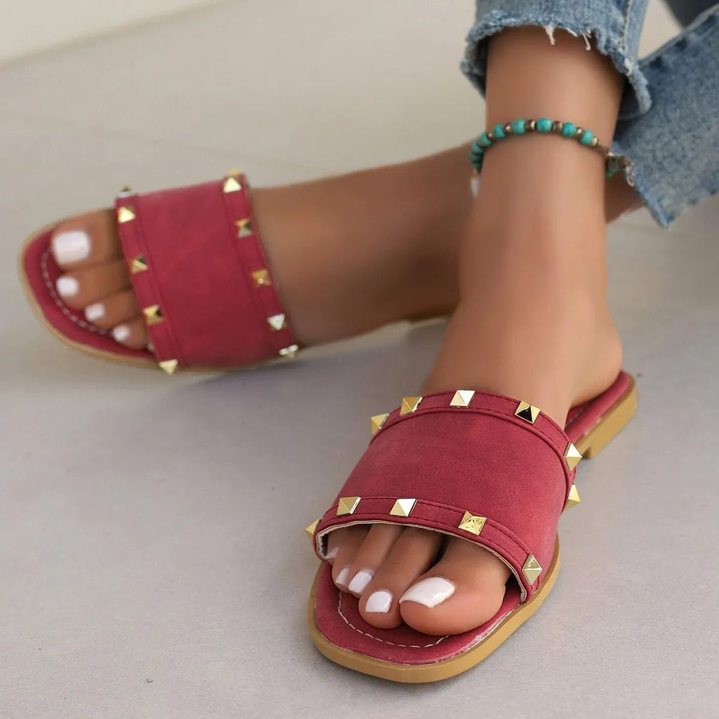 Women's chic studded open toe flat sandals made of vegan leather, featuring comfortable slip-on design and stylish embellishments.