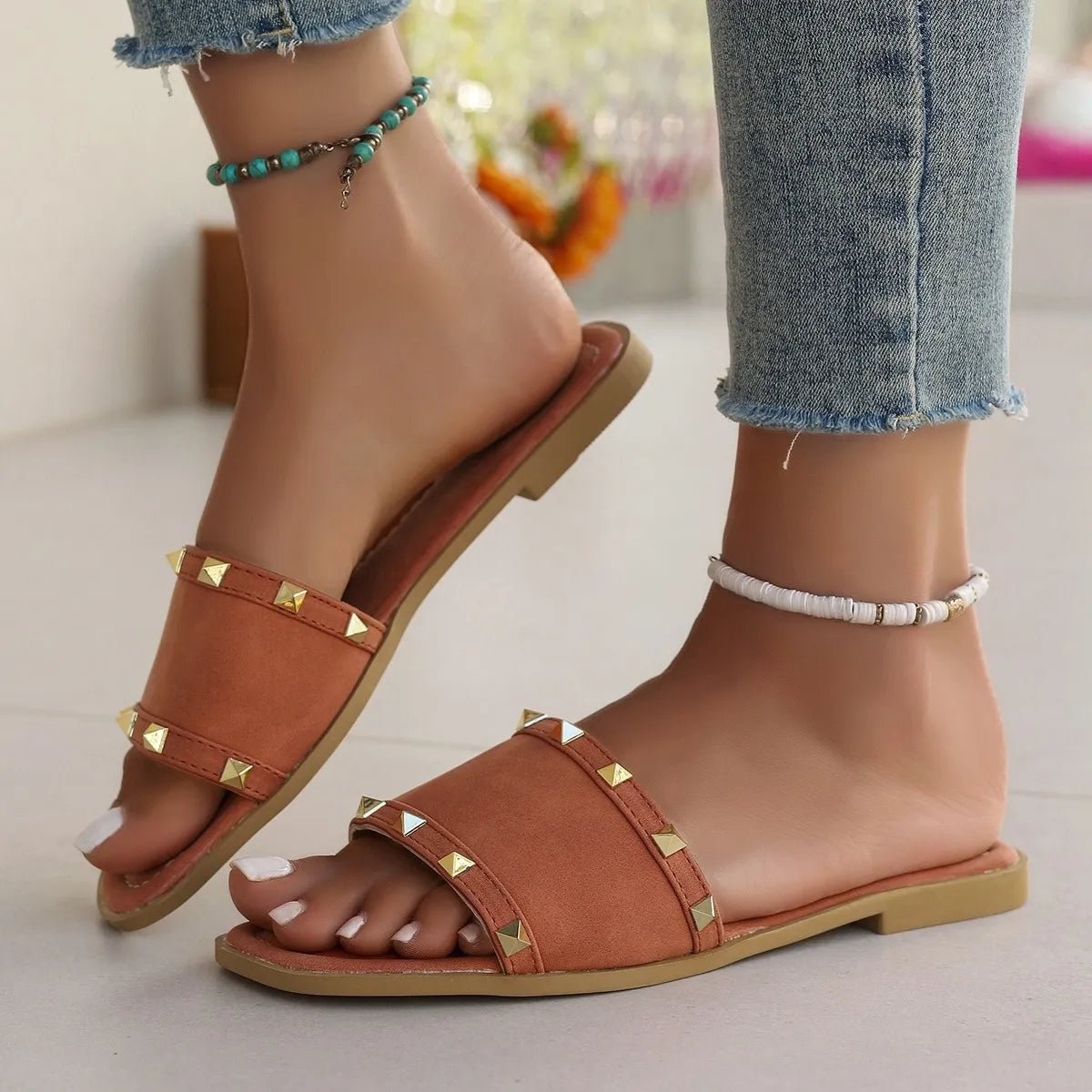 Women's chic studded open toe flat sandals made of vegan leather, featuring comfortable slip-on design and stylish detailing.